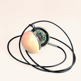 labyrinth inspired peach locket half open to reveal some worms hidden inside